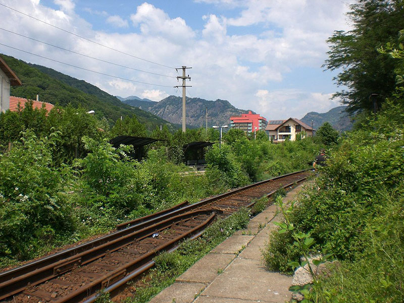 Bahnhof Pauscha mit Hochhaus und Bergen im Hintergrund