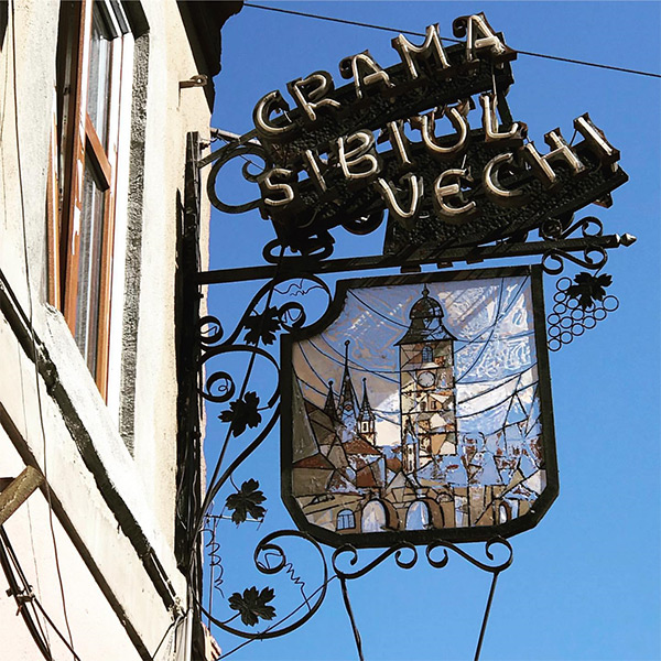 Außenwerbungsschild mit der Aufschrift Crama Sibiul Vechi und dem gemalten Stadtturm