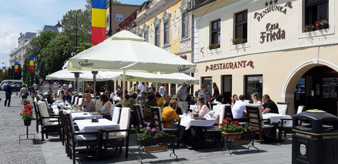 Menschen sitzen vor dem Restaurant Casa Frieda und essen