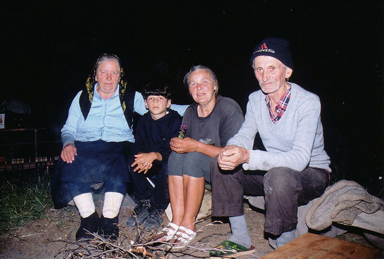 Foto von Menschen welche um die Feuerstelle sitzen