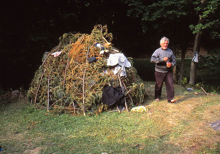 Foto von Hütte aus Zweigen mit Mann davor