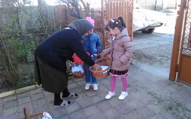 Kinder überbringen einer Oma einen Korb mit Geschenken