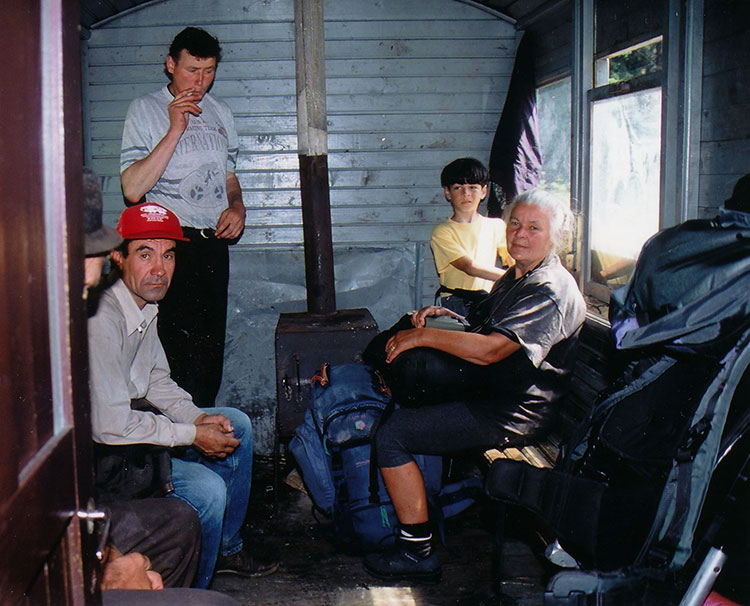 Foto von Christine und Michele im Inneren des Waggons neben einem Holzofen