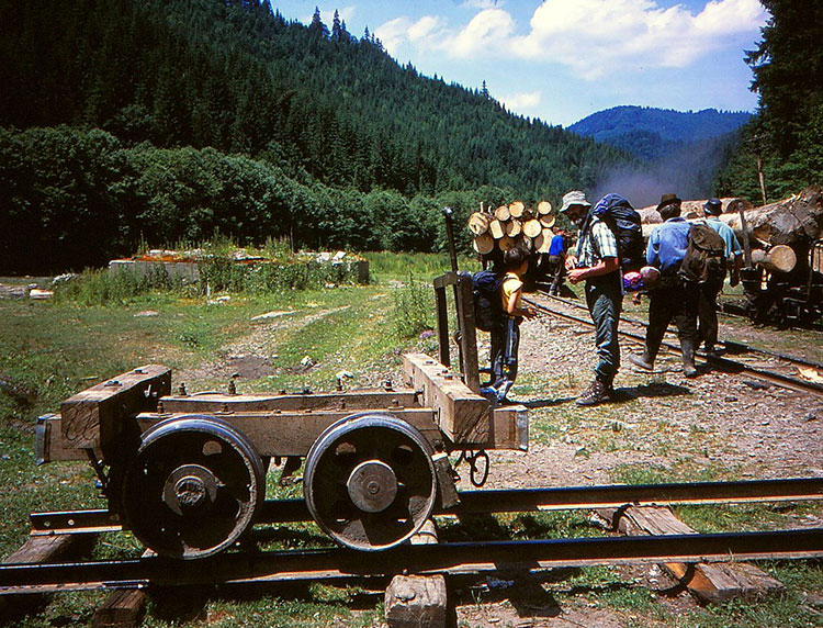 Foto einer Beladestelle für Holzwaggons mit dem Autor und Michele mit Wanderrucksack