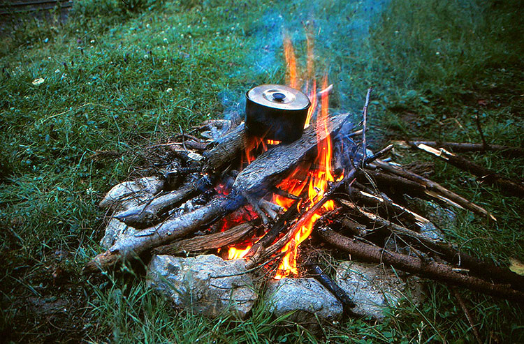 Foto von Lagerfeuer mit Kochtopf auf dem Holz stehend