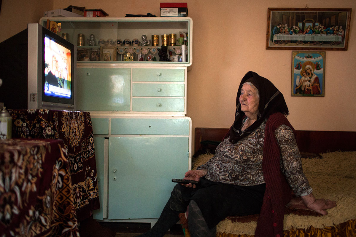 Großmutter vor dem Fernseher sitzend