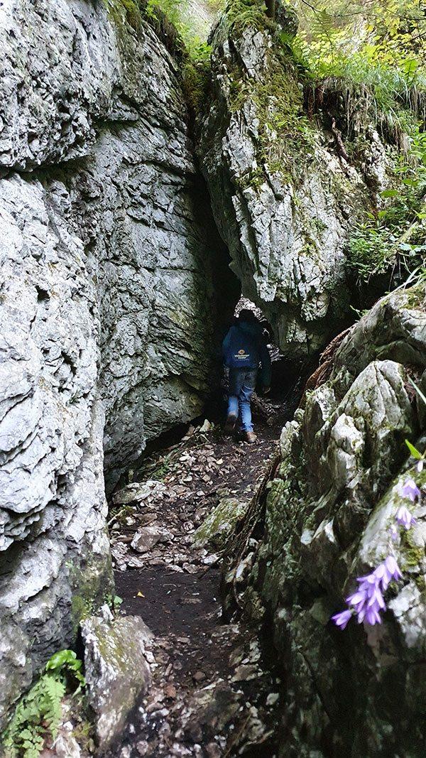 Alexander klettert duch ein schmales Loch