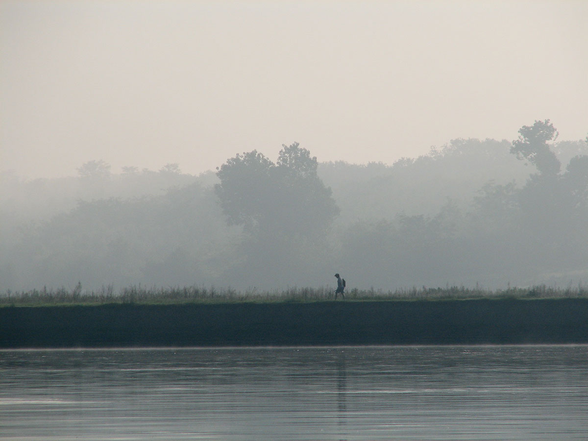 Morgenstimmung an der Donau mit Angler welcher am Ufer entlangläuft