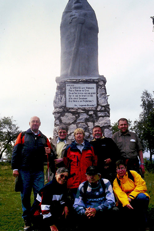 Reisegruppe posiert für Foto vor Denkmal