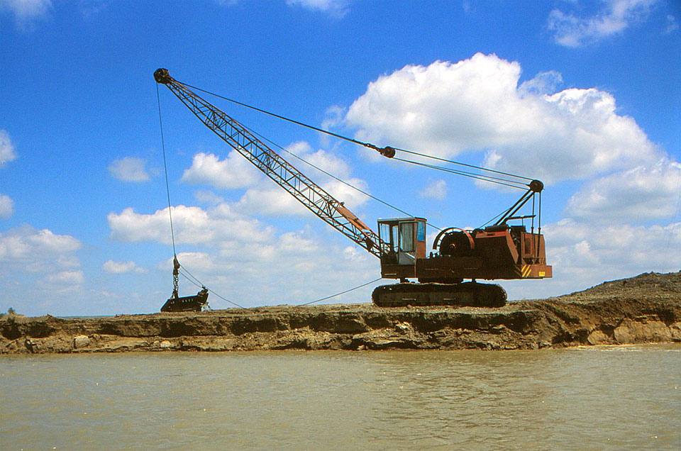 Bagger steht am Fluss