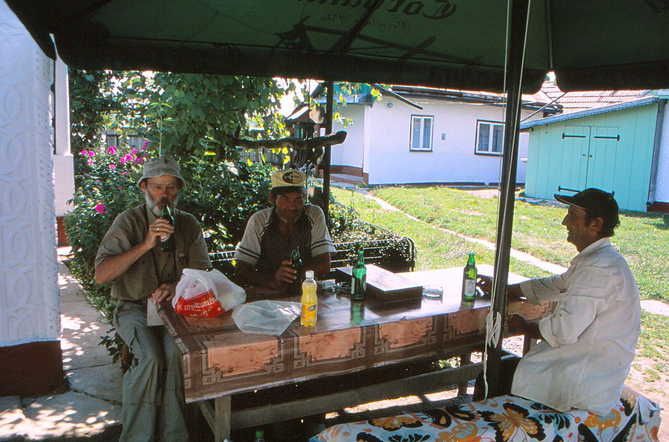 Autor mit zwei Männern vor der Dorfkneipe sitzend