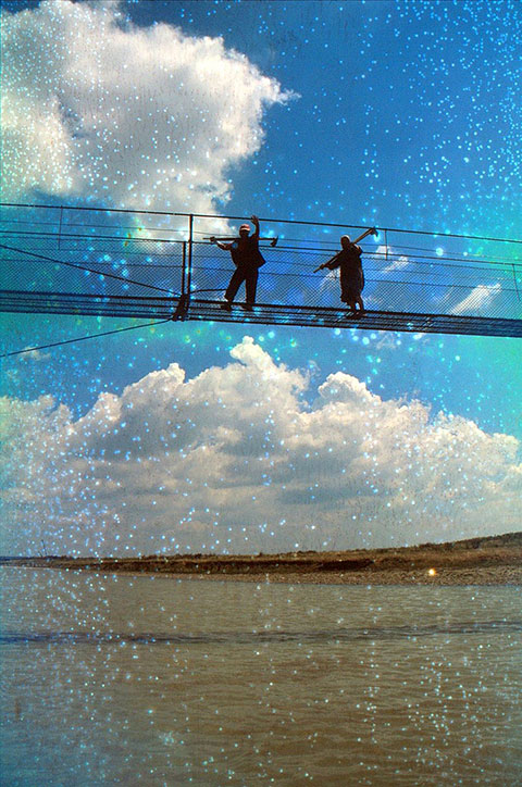 Menschen winken auf Hängebrücke