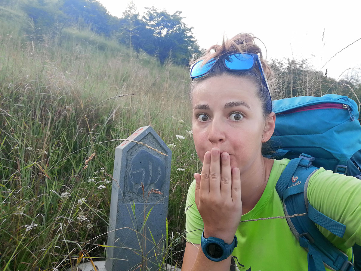 Selfie von Anca vor einer Stele mit einem aufgemalten Bären