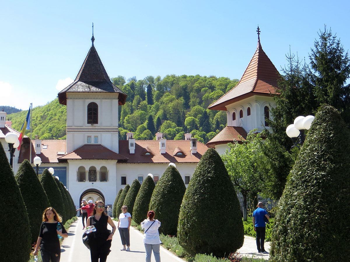Besucher laufen auf dem Weg vor dem Klostereingangstor
