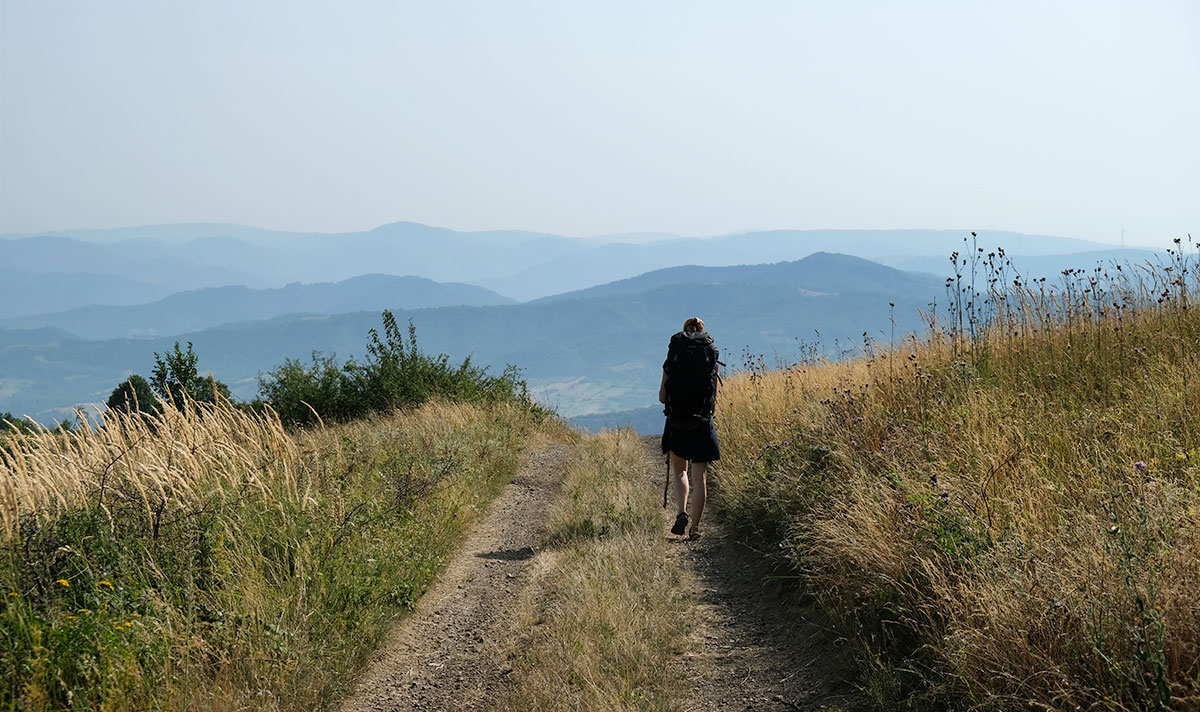 Wanderin auf einem Weg mit Weitsicht auf die Berge