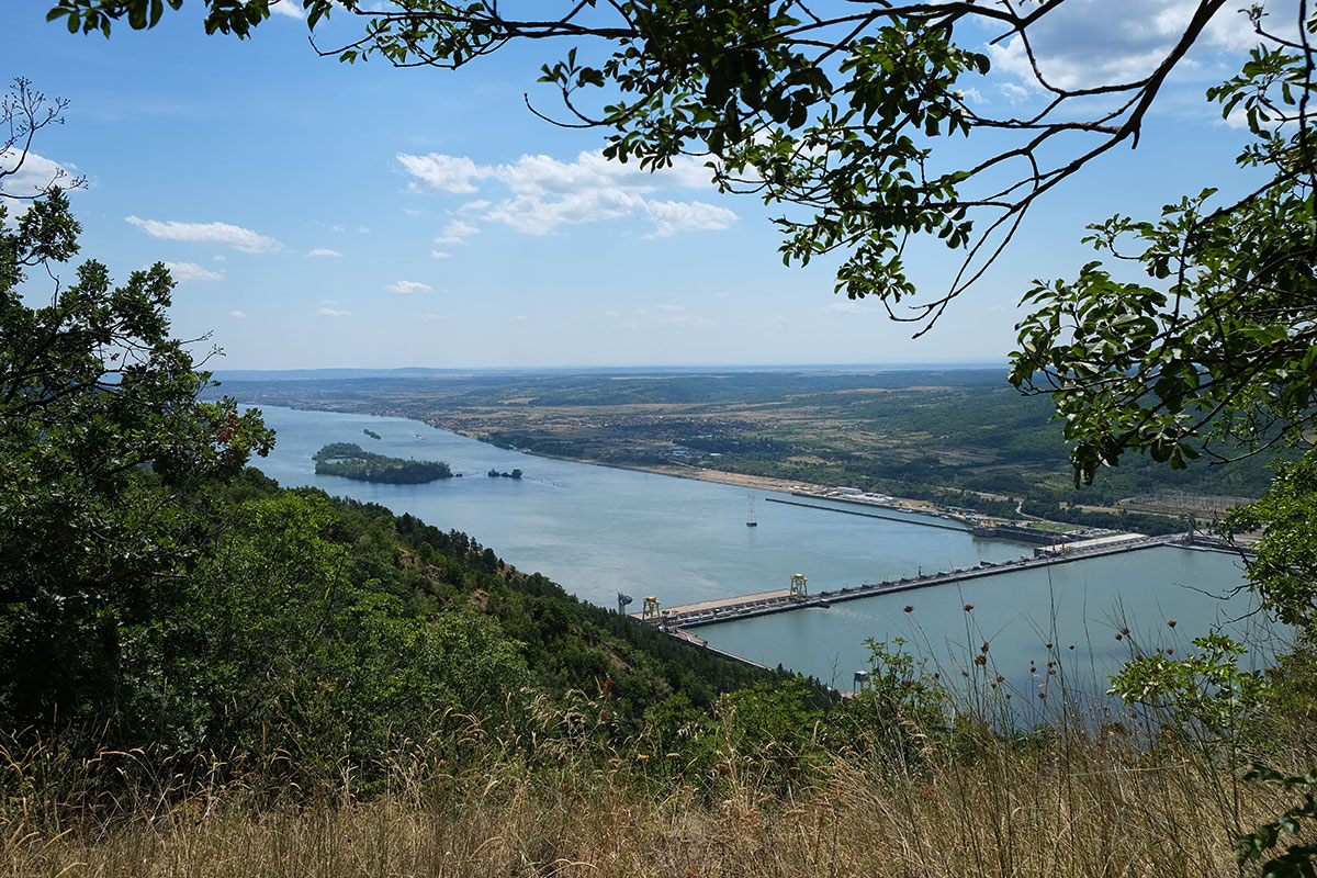 Blick von einem Berg auf einen Staudamm der Donau
