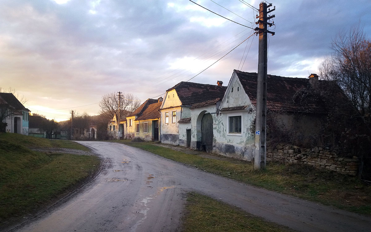 unbefestigte Dorfstraße mit alten Häusern