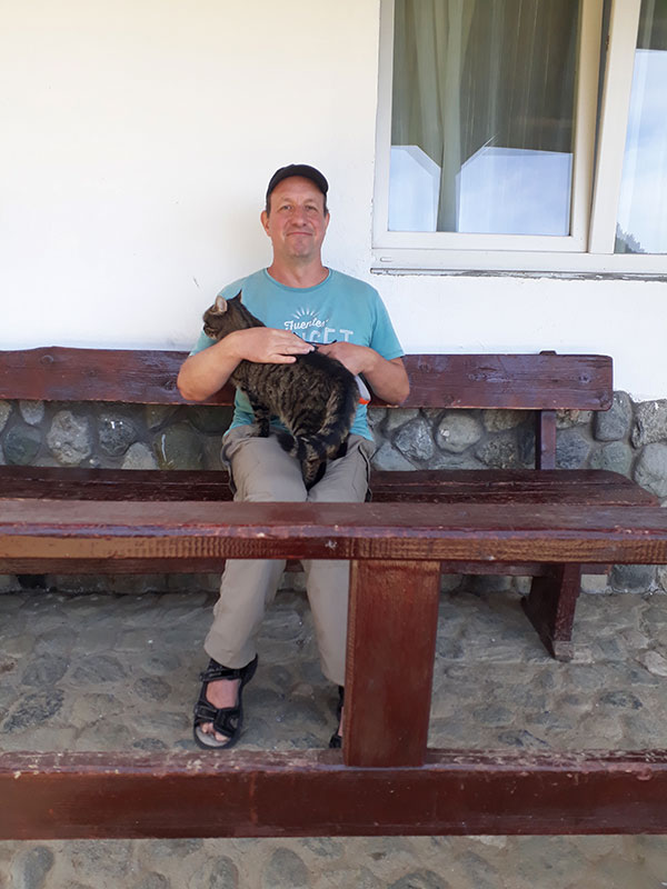 Autor mit Katze auf einer Bank sitzend