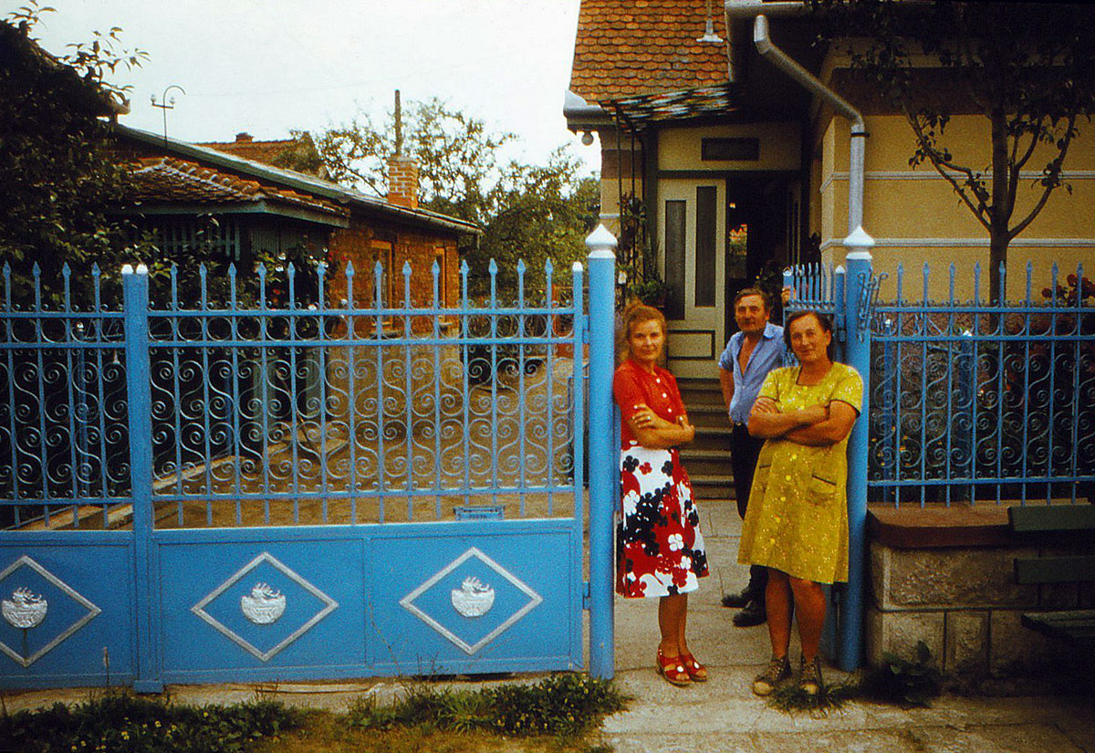 Menschen stehen im Eingang eines Hofes vor ihrem Haus
