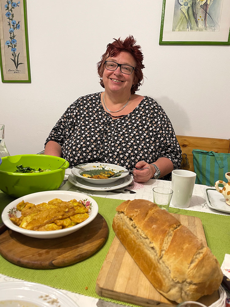 Gudrun sitzt strahlend am Essenstisch