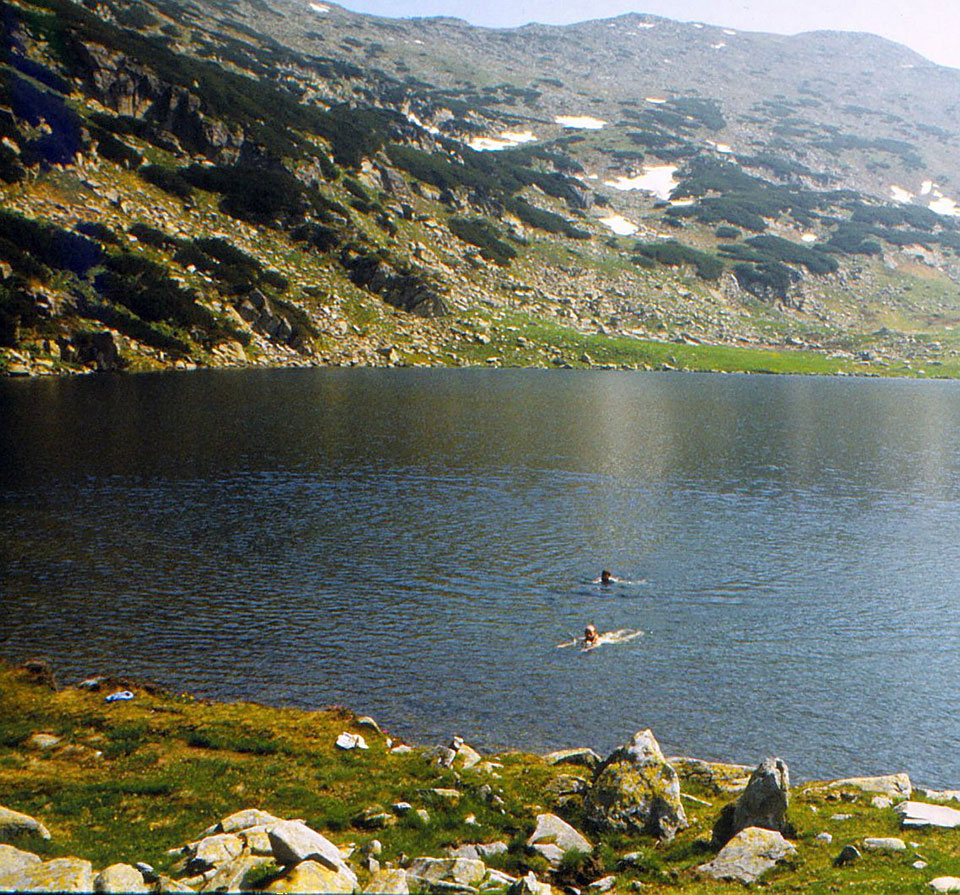 Menschen schwimmen in einem Bergsee