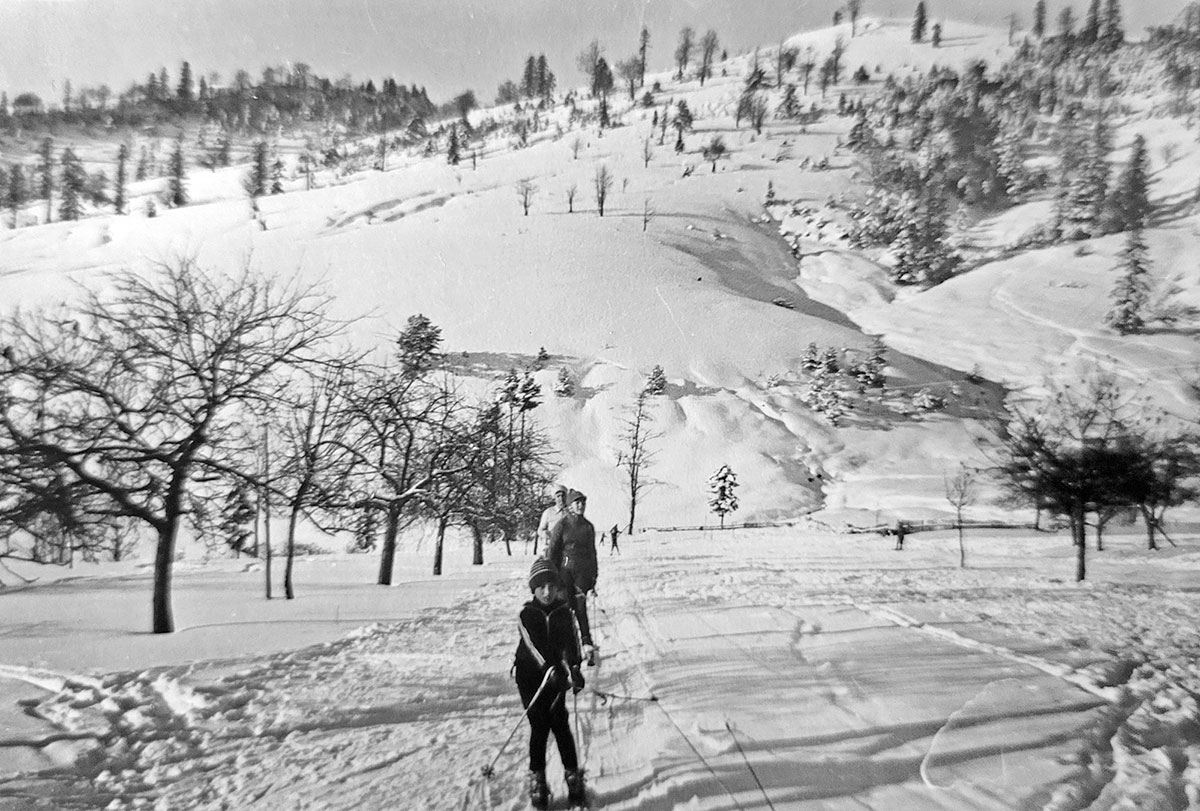 Kinder lassen sich an einem Seil einen Berg hochziehen