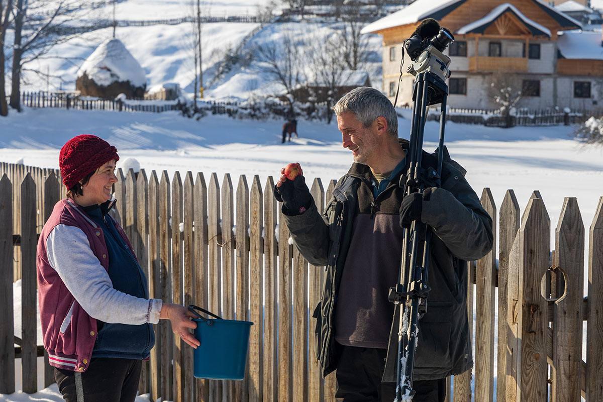 Frau reicht Mann einen Apfel