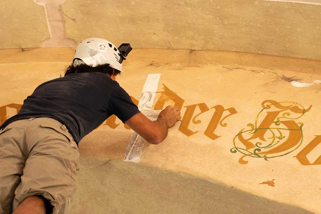 Mann malt an einer Wand