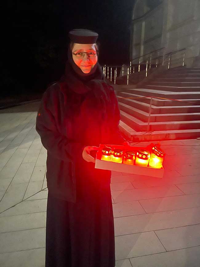 Nonne mit Kerzen in der Hand