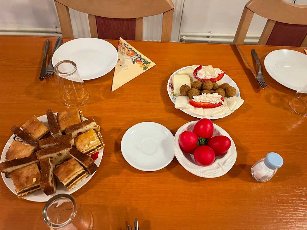 gedeckter Tisch mit Kuchenteller, Käseteller und gefärbten Eiern
