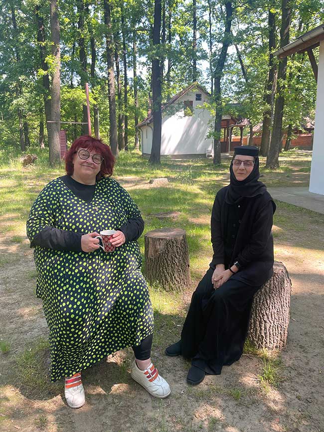 Autorin sitzt mit einer Nonne im Park