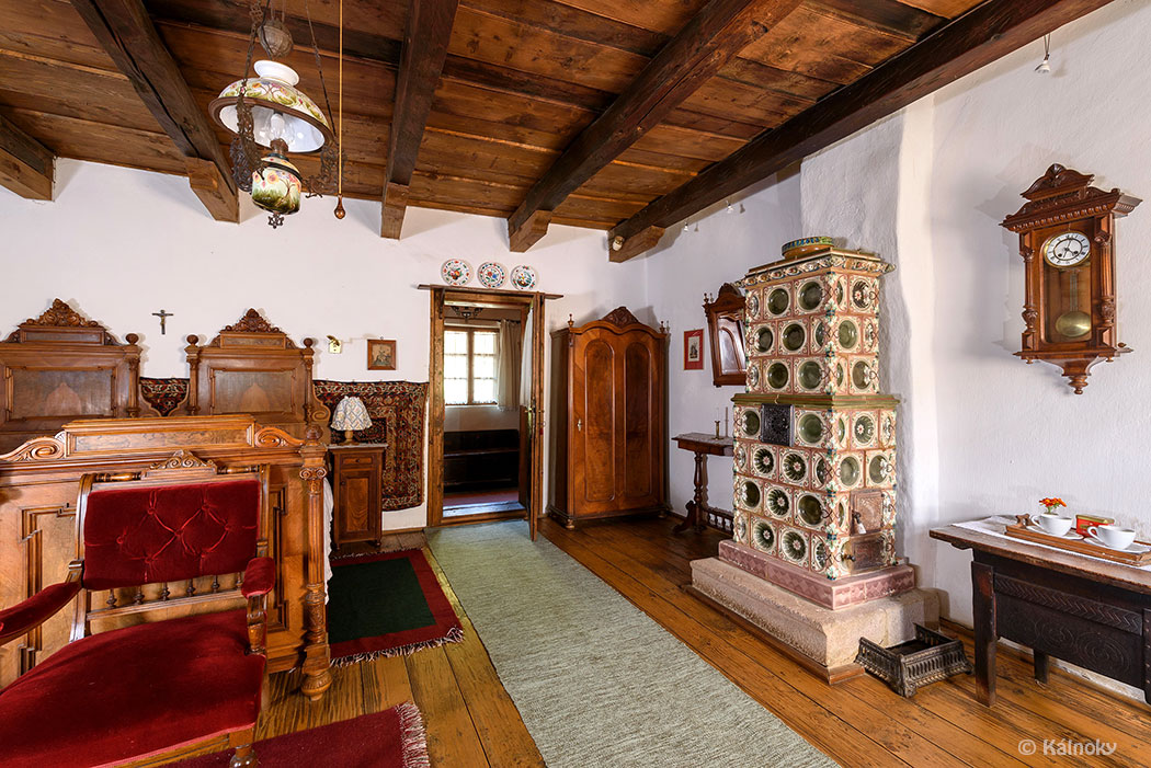 königlich eingerichtetes Zimmer mit alten Möbeln und verziertem Kachelofen