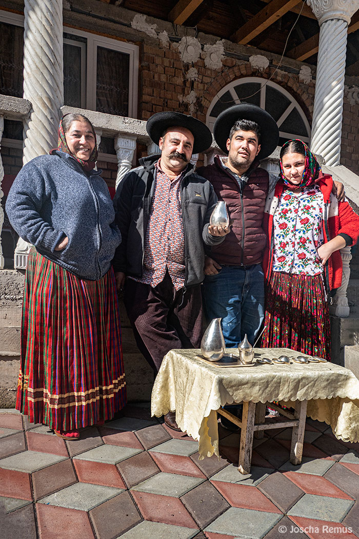Kunstschmied mit Familie in Trachten vor Kunstwerken stehend