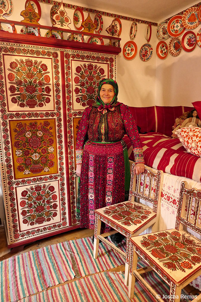 Frau in Tracht in einem verzierten Zimmer stehend