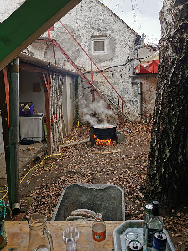 ein dampfender Kessel steht auf einem Feuer im Hof