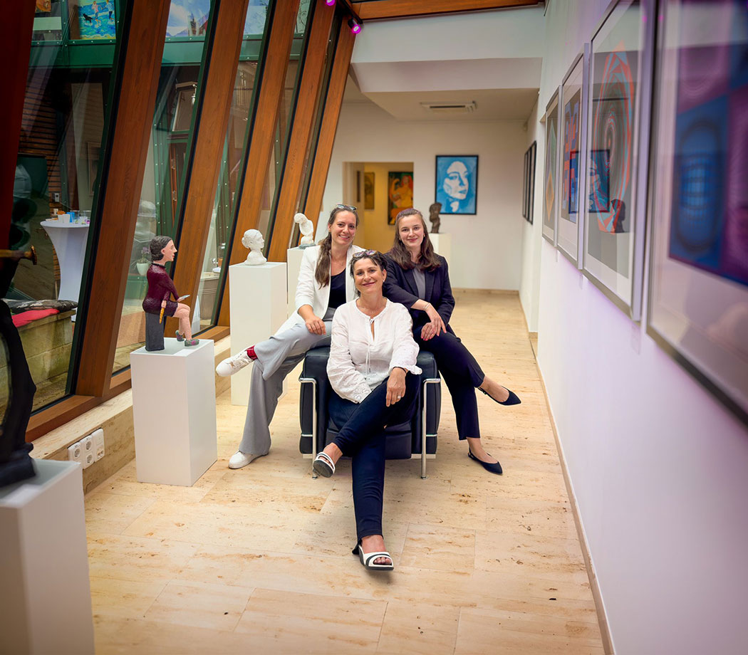 drei Frauen sitzen in einer Galerie