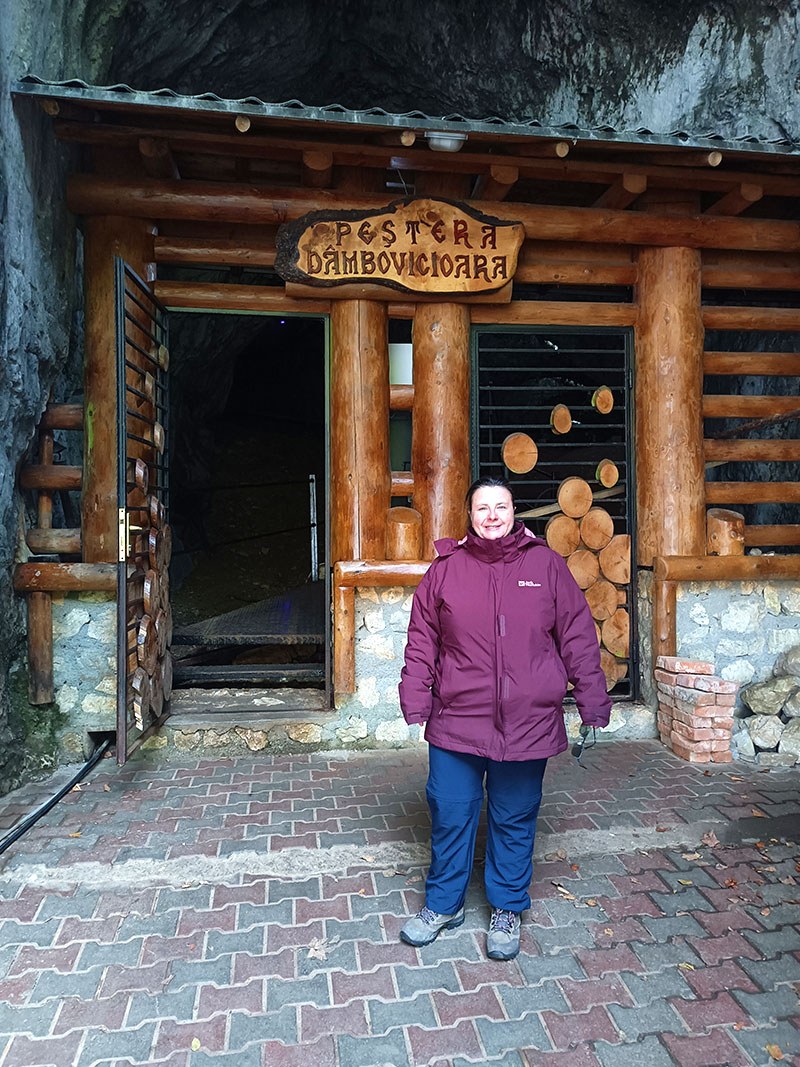Frau vor einem Holzhaus