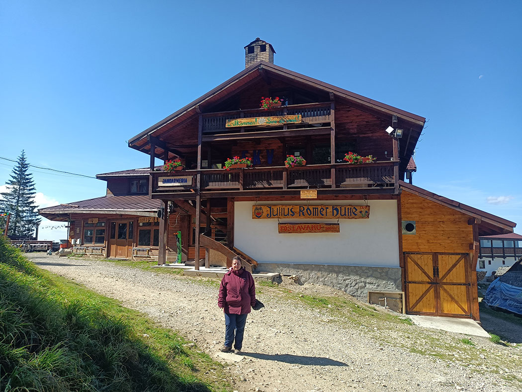 Frau vor einer Berghütte