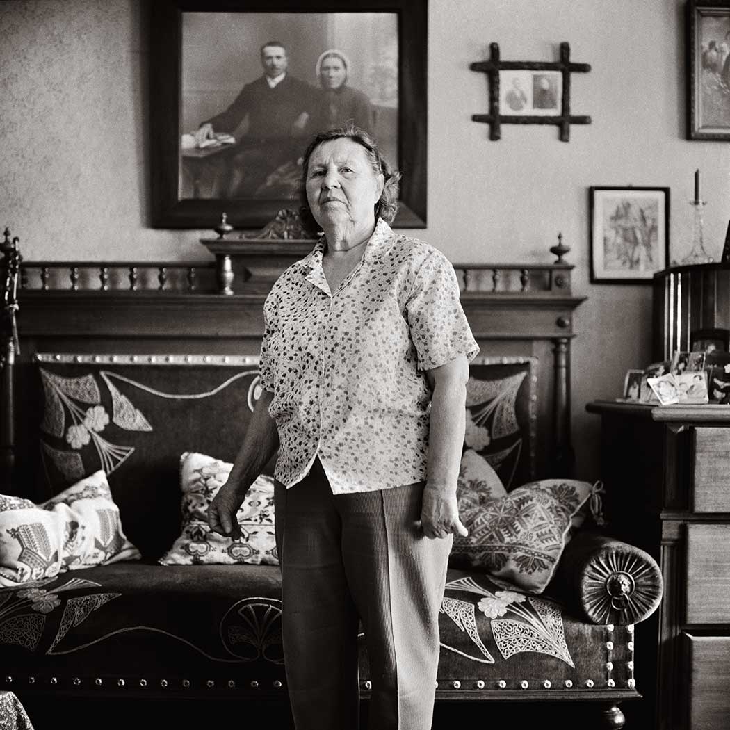 schwarz-weiß Portrait einer Frau vor einem Sofa
