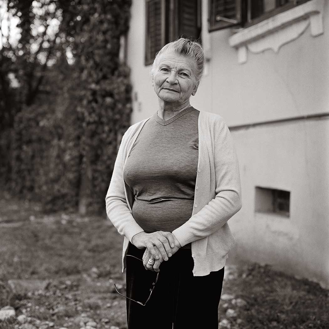schwarz-weiß Portrait einer Frau vor einem Haus