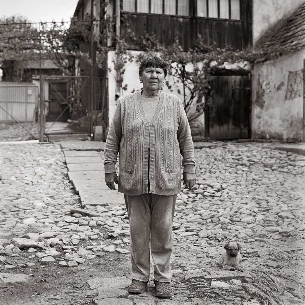 schwarz-weiß Portrait einer Frau im Hinterhof stehend