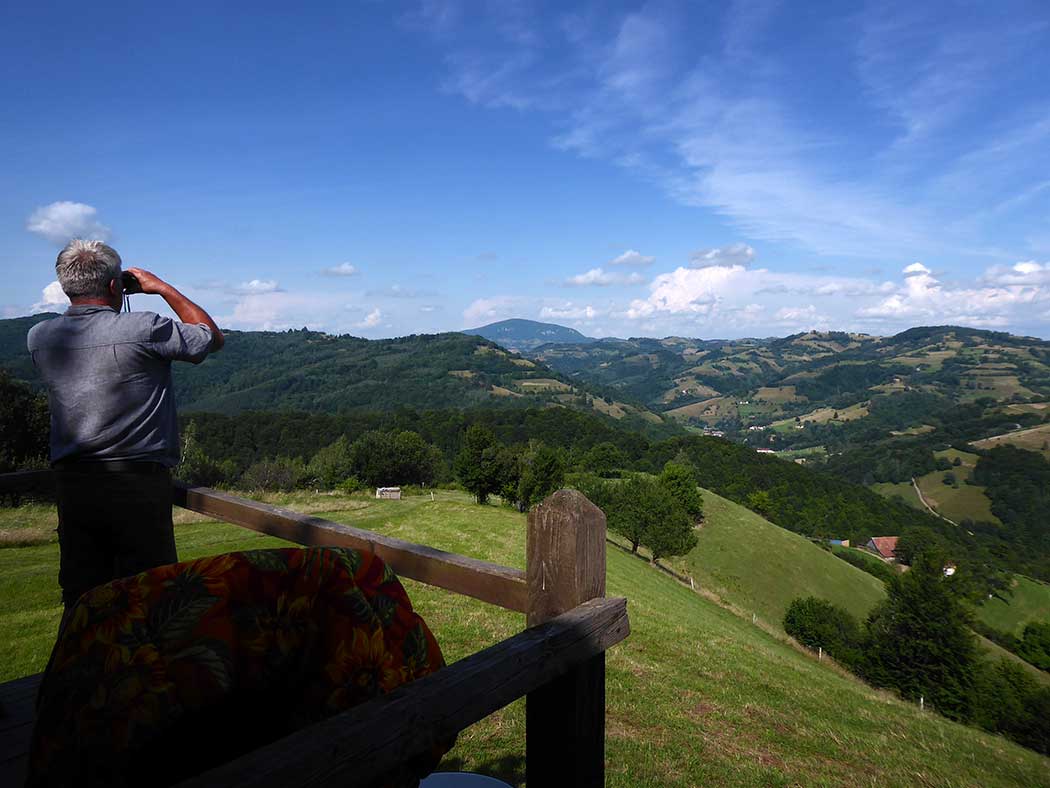 Mann schaut mit einem Fernglas in die Bergwelt