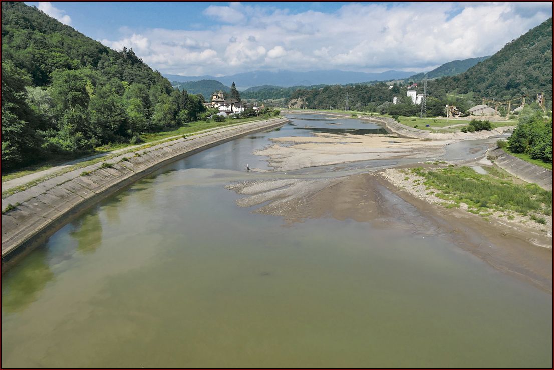 Fluss mit Dorf und Berglandschaft