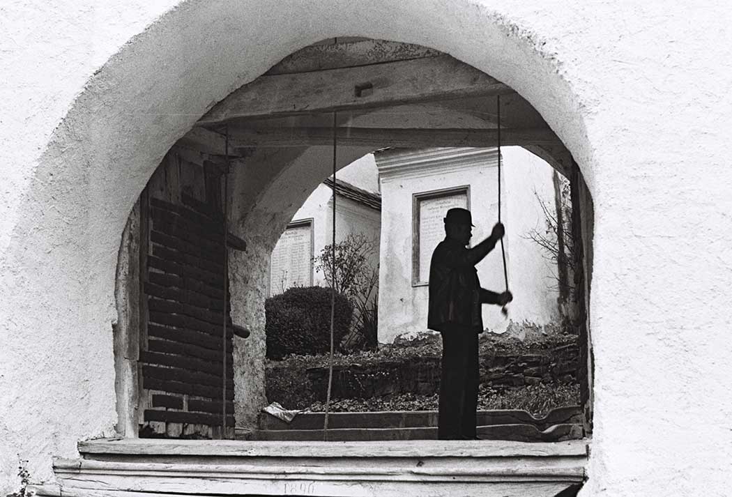 Mann läutet eine Glocke