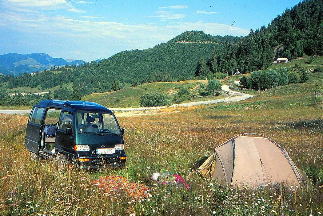 Zelt und Auto auf einer Bergwiese